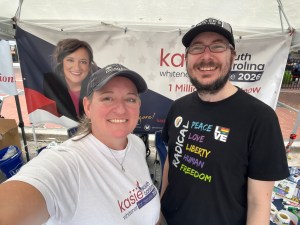 Casey Crowe and Kasie Whitener stand in front of the Kasie banner at SC Pride
