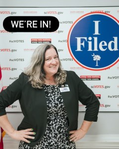 Kasie standing in front of the "I Filed" sign at the SC elections commission