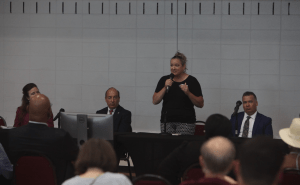 Kasie speaks into a microphone behind a table where candidates were seated.